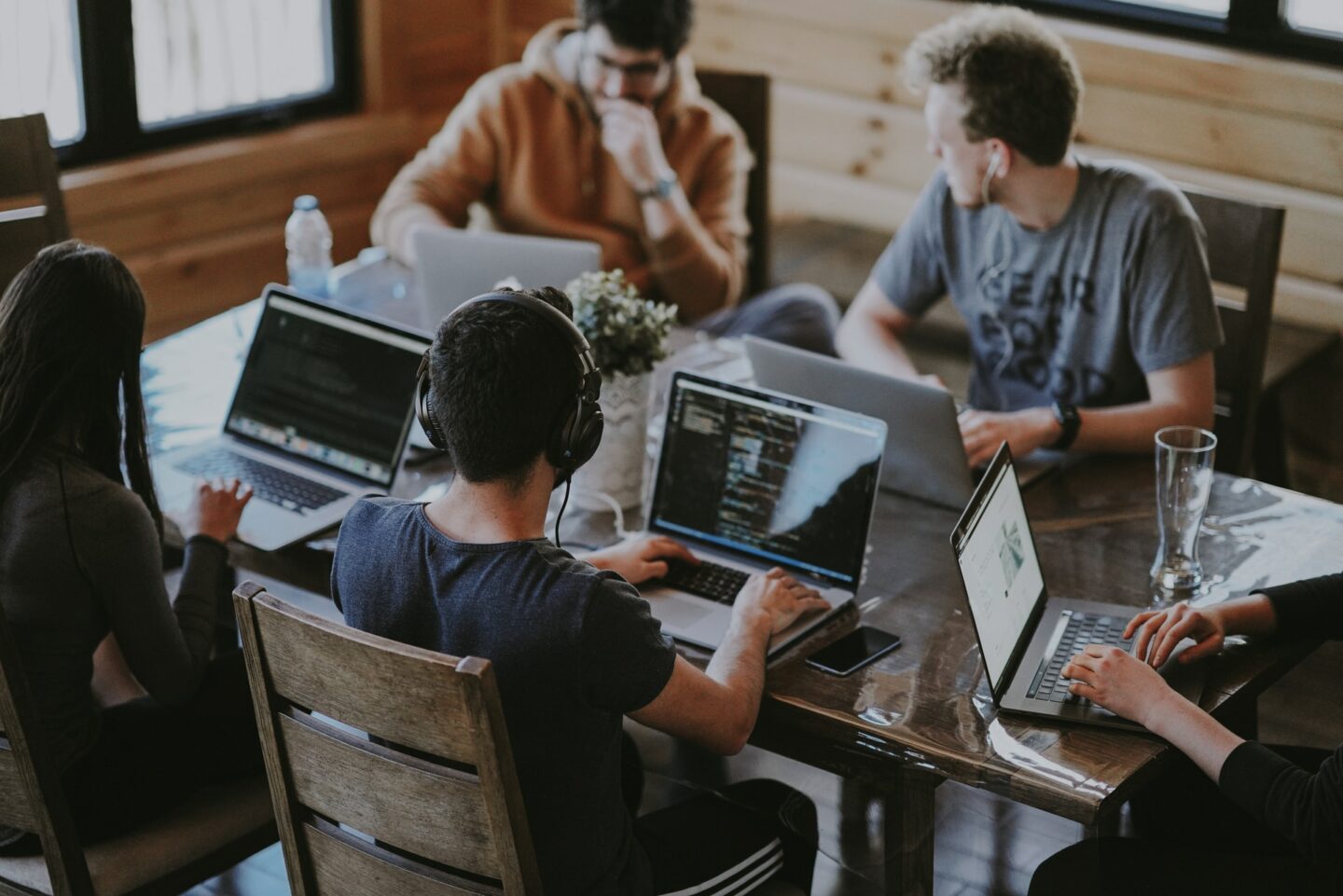 Four people working on laptops