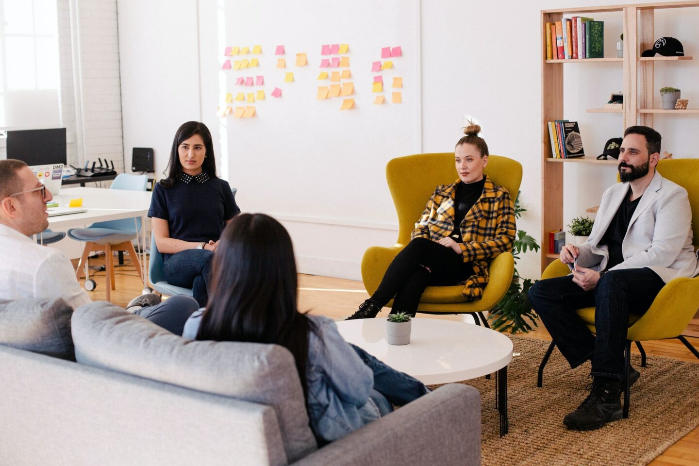 Five people sat in a group around a coffee table