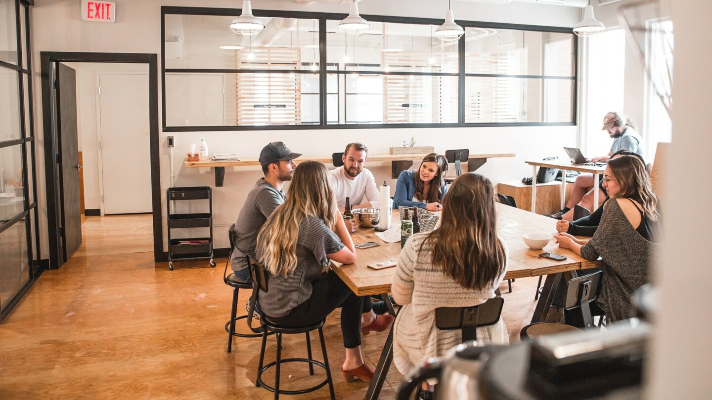 Group of individuals sat at a table in an office