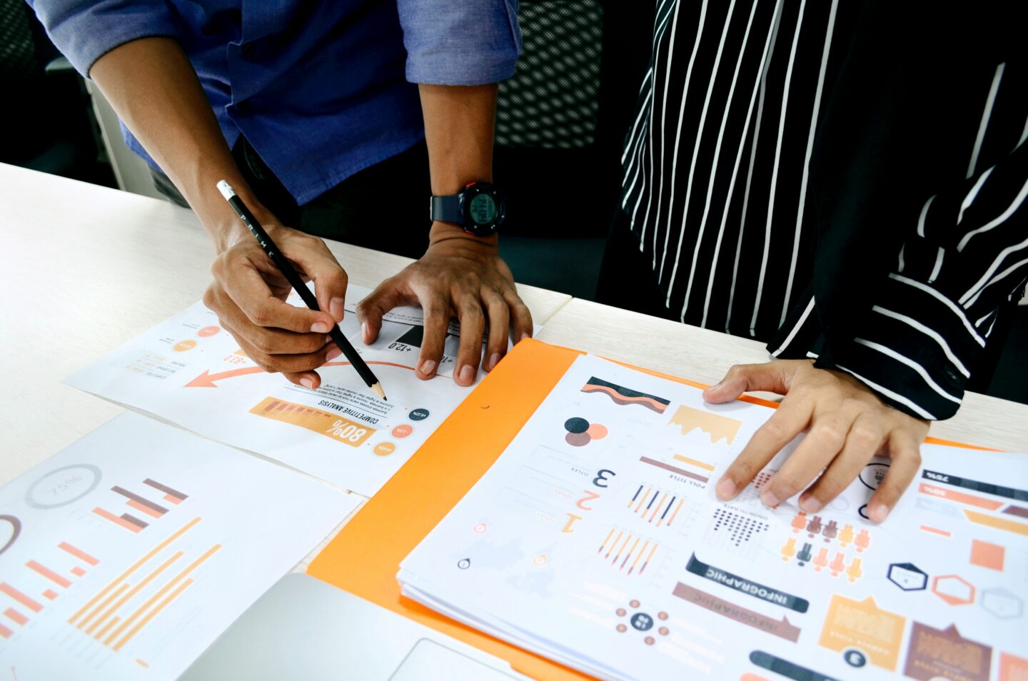 Two people annotating printed graphs and models