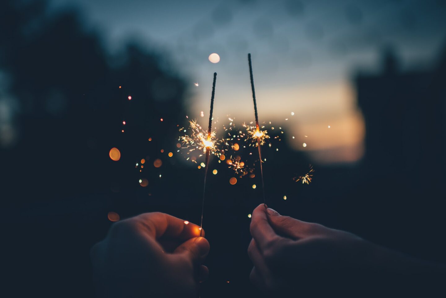 Two people holding two sparklers