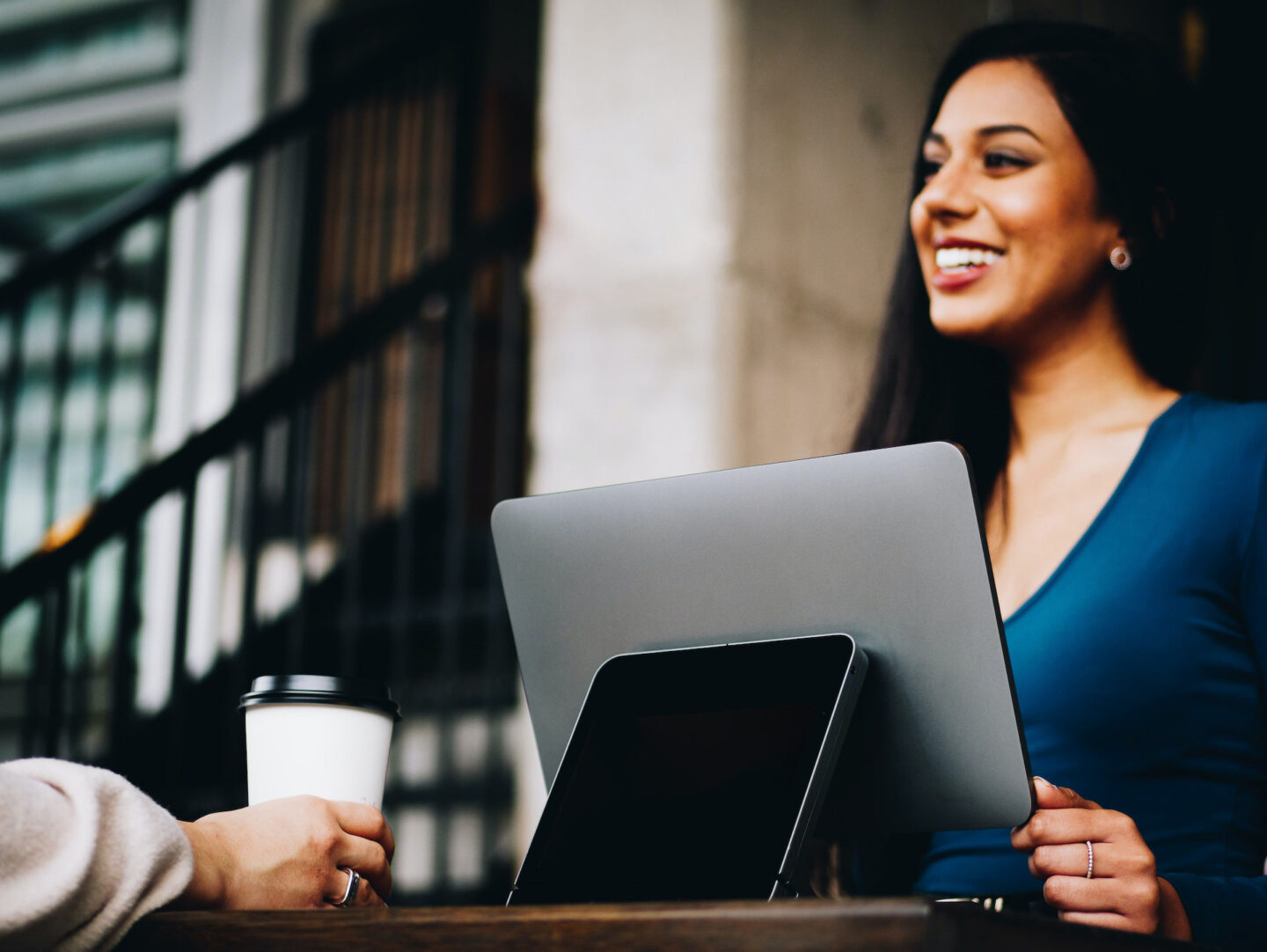 Woman sat in front of a laptop screen smiling