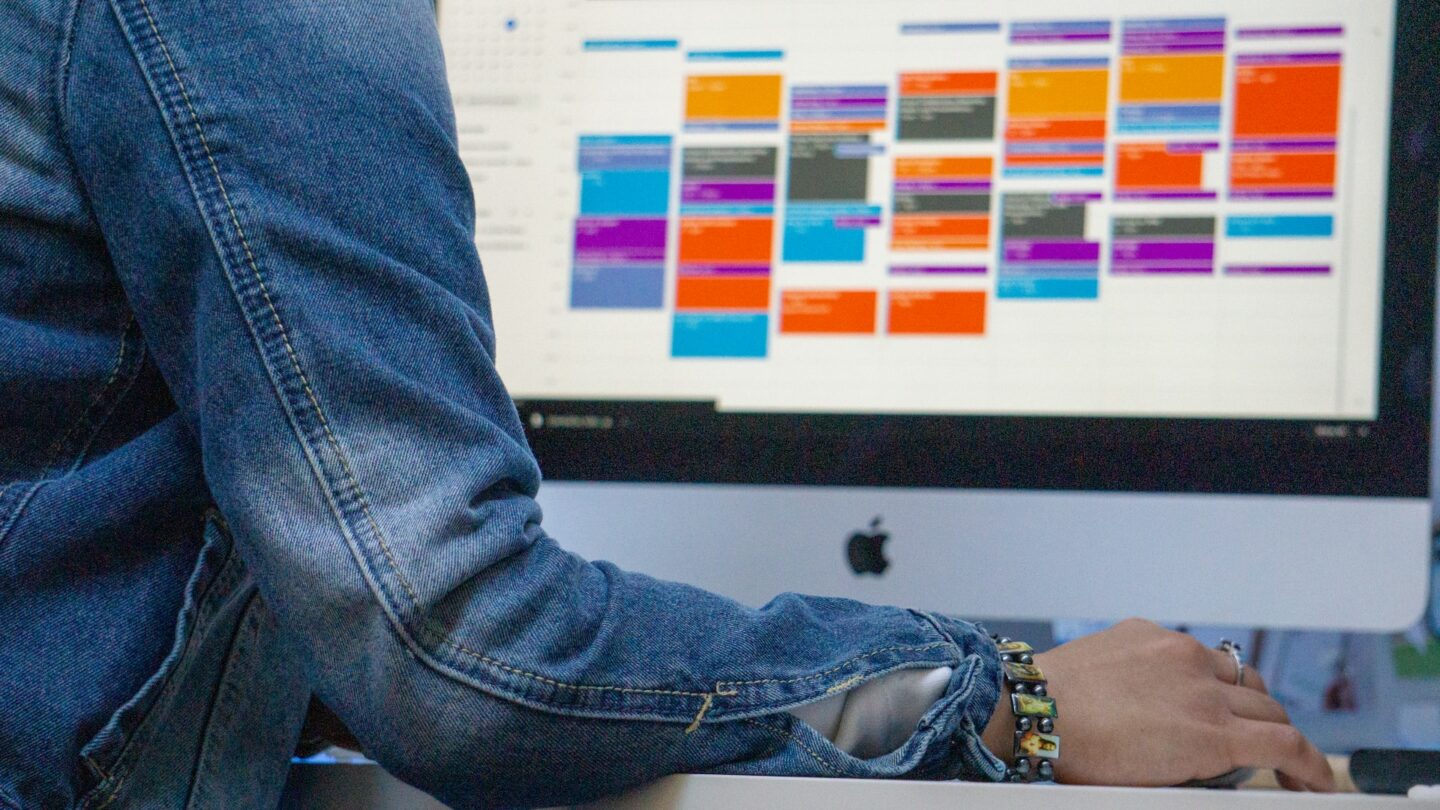 Photograph of person sat in front of work calendar on computer screen