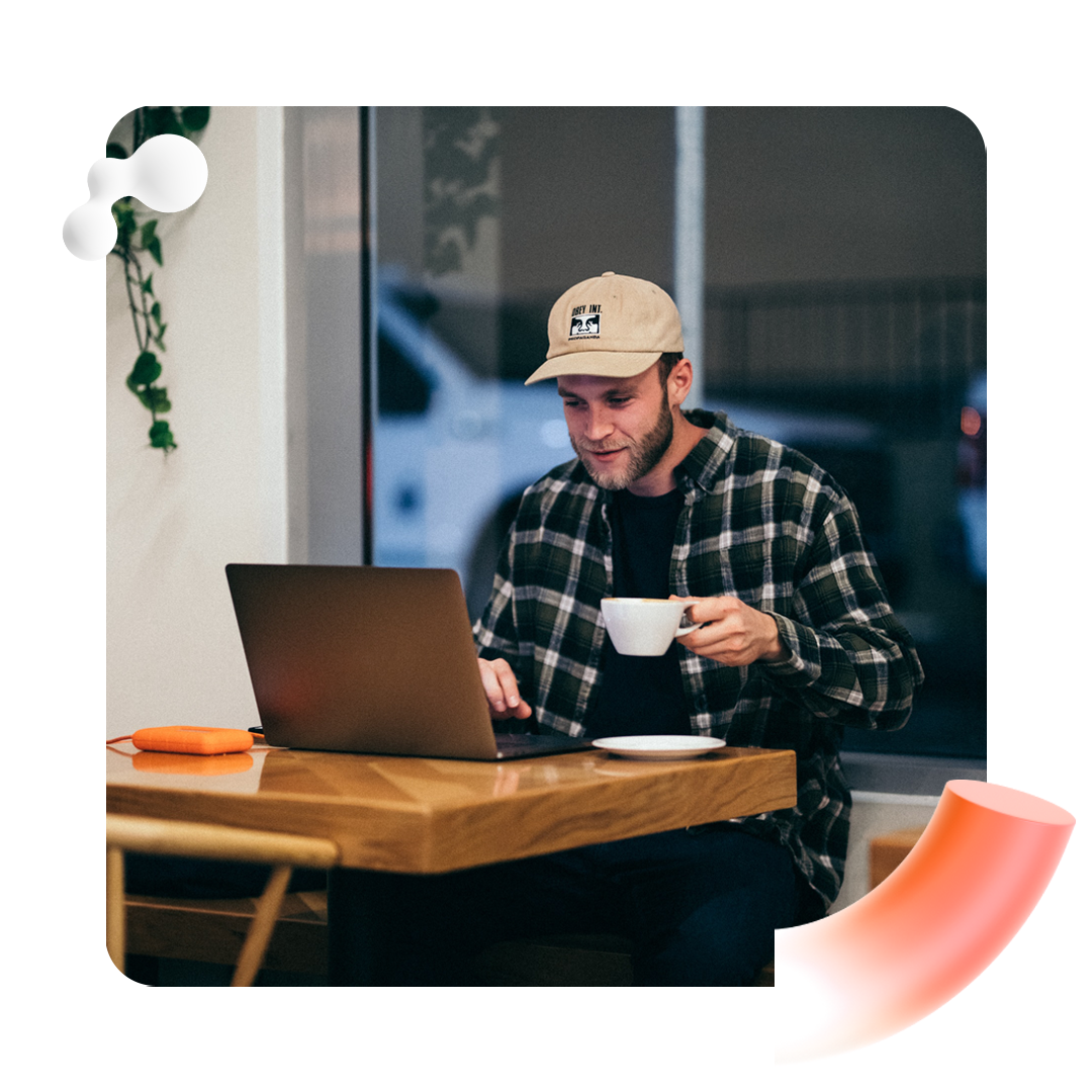 Person working at laptop drinking coffee