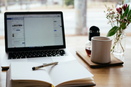 View How to Build a Survey Tool Users Really Need Photo of a notebook in front of a laptop screen