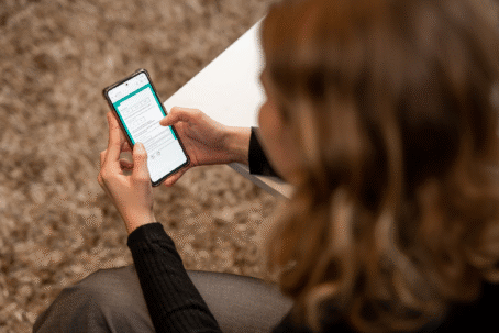 View A Guide to Our Data Creation Process Woman looking at a phone displaying an online survey