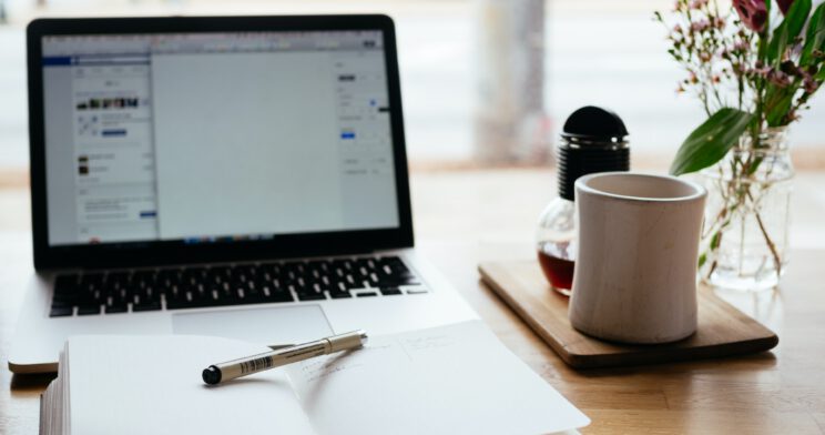 Photo of a notebook in front of a laptop screen