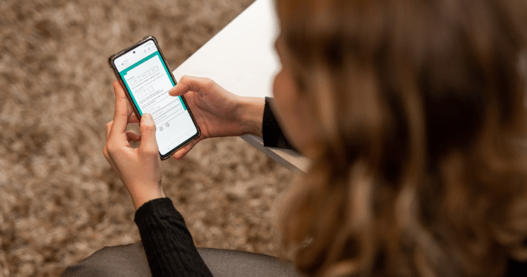 Woman looking at a phone displaying an online survey